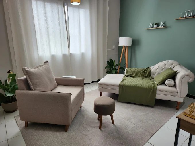Sala do consultório com poltrona, divã, tapete e plantas